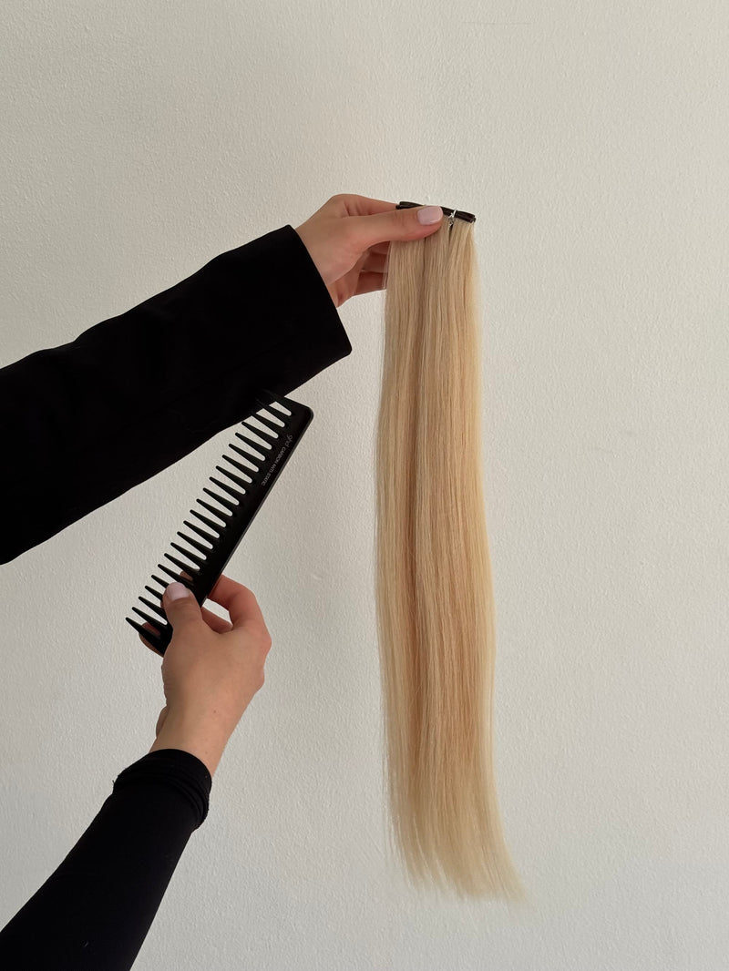 Blonde weft wordt met een kam verzorgd