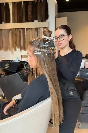 Stylist plaatst hairextensions met microringen volgens de IBE methode